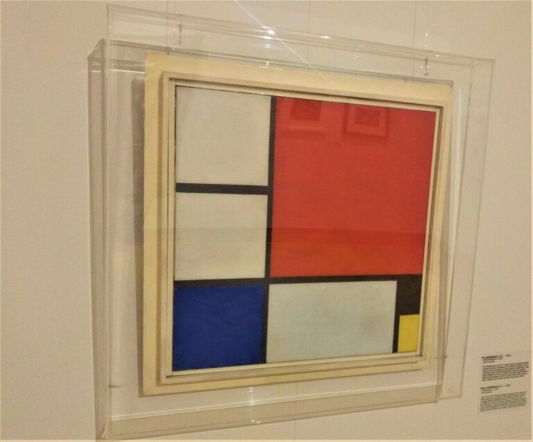 slikarsko platno Mondriana izdeljeno crnim linijama sa dominantnim crvenim poljem , manjim plavim i najmanjim žutim i crnim poljem